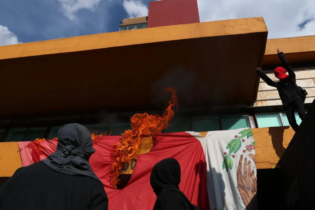 Encapuchados queman bandera de México