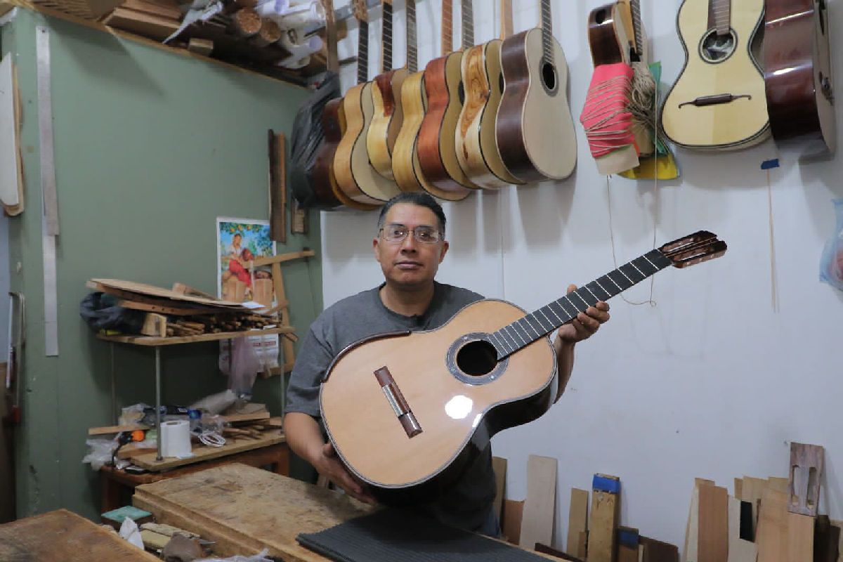 artesano expone sobre guitarras de Paracho en Michoacán